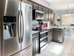 It's true, not everyone wants white kitchen cabinets! Check out the before and after photos of how this dated 90's kitchen went from honey Oak to Dark Chocolate!