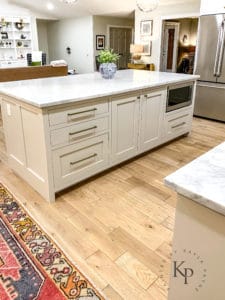 Carrara Marble countertop on kitchen island. White Oak hardwood floors in kitchen